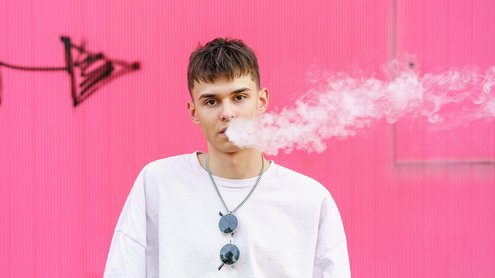 Mann dampft E-Zigarette. Frontalansicht mit Dampf Mann dampft E-Zigarette. Frontalansicht mit Dampf