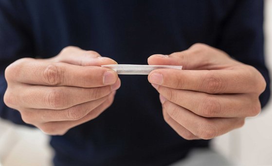 Tabakerzeugnisse Hände, die eine Zigarette drehen.