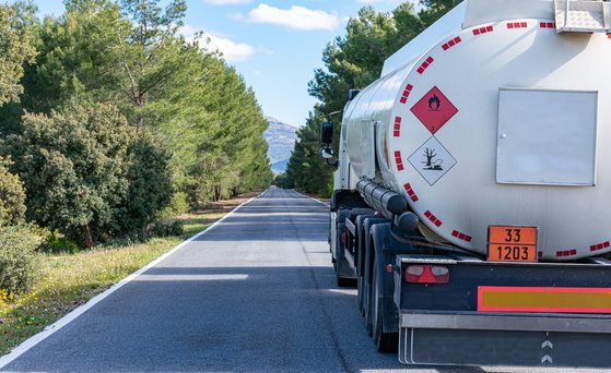 Fahrzeug, LKW, Tankfahrzeug, mit Warnschildern. Von hinten fotografiert, vorbei am Fahrzeug auf linker Spur.